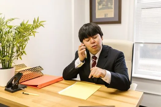 adult child calling city office about medical aid denture registration while elderly parent reviews dental estimate at home table, realistic Korean healthcare support photo | 의료급여 틀니 등록 승인 여부를 시군구에 확인하는 장면