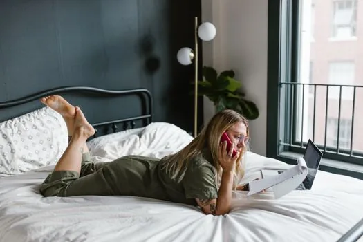 Adult child calling welfare equipment provider while checking hospital admission schedule and electric bed rental paper