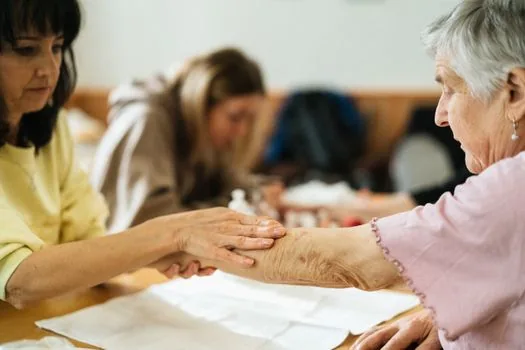 adult child helping senior parent check food voucher balance on smartphone beside receipts and grocery bag, warm indoor light, realistic welfare photo