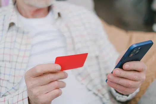 adult child placing parent ID card, small portrait photo and benefit certificate beside a senior welfare center application form, realistic editorial photo | 회원가입 준비서류 | 신분증·사진·감면서류를 방문 전에 나눠 확인하는 장면