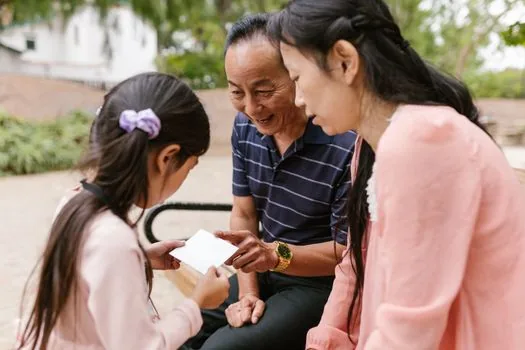 Adult child preparing family relationship certificate, ID card cover and pension claim checklist for elderly parent, realistic Korean home office photo