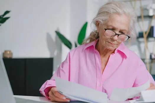 adult child preparing power of attorney, ID copies and pension certificate application at home desk | 국민연금 수급증명서 대리 발급 전 위임장과 신분증을 준비하는 장면