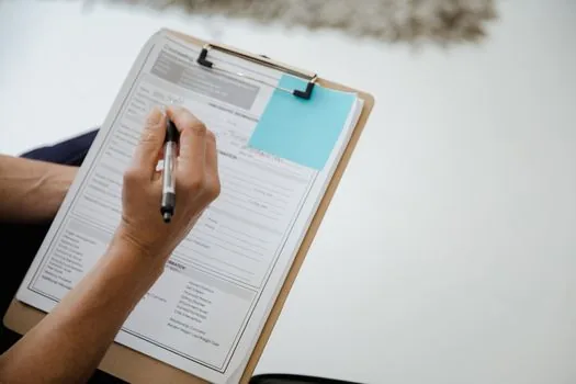 adult child writing senior job application checklist with phone number 1544-3388 and local center memo