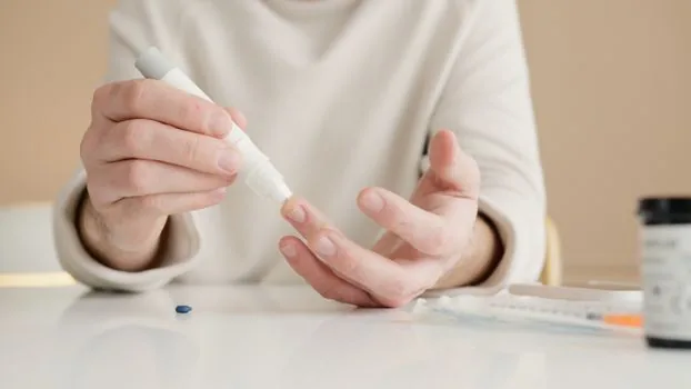 Elderly parent and adult child filling chronic disease registration consent form at a neighborhood clinic desk