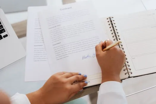 Korean adult child and care center staff reviewing long term care service contract, calendar and bathing service schedule at home table, realistic document photo | 방문목욕 제공기관 계약서와 이용 일정을 확인하는 장면