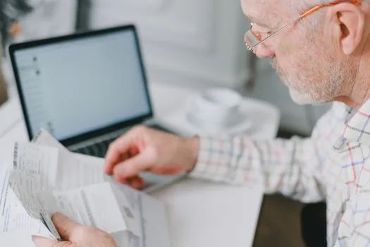 Korean bank consultation desk with elderly parent checking protected pension account terms and automatic payment list
