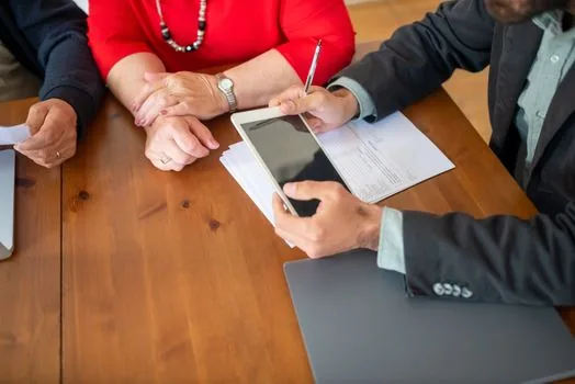 Korean family meeting at public pension office consultation desk with dementia asset management documents and calm counselor, realistic photo | 국민연금공단 상담 창구에서 재산관리 서류를 확인하는 장면