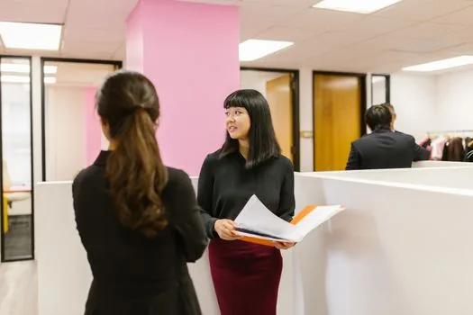 Korean senior employment counselor explaining internship program documents and training schedule to older applicant