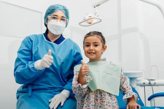 Korean senior patient and adult child speaking with dentist beside dental chair, insurance papers on desk, realistic warm clinic photo | 부모님 임플란트 급여 상담 장면 | 치과 상담 전 대상 기준을 확인하는 설명 이미지