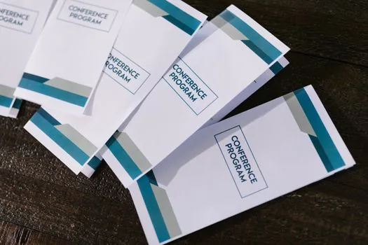 Korean senior welfare center front desk with membership forms, ID card holder and program pamphlets, bright realistic public service photo | 노인복지관 회원등록 상담 | 부모님 주소지와 회원가입 서류를 접수창구에서 확인하는 장면