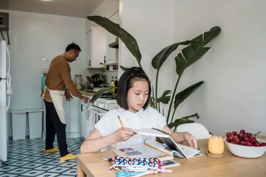 older Korean parent and adult child checking community center exercise class notice on smartphone at kitchen table, health booklet and calendar nearby, realistic warm home photo | 부모님과 가족이 건강100세운동교실 모집 공지를 확인하는 장면