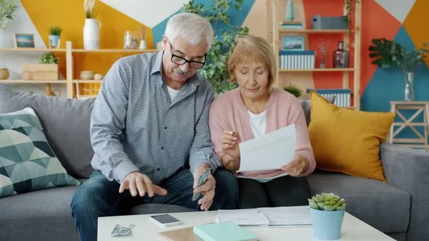 senior family organizing death certificate, family relation certificate, bankbook and national pension notes on a bright wooden table, realistic Korean editorial photo
