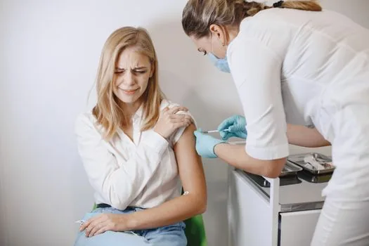 Senior parent resting in clinic waiting area after vaccination with adult child nearby