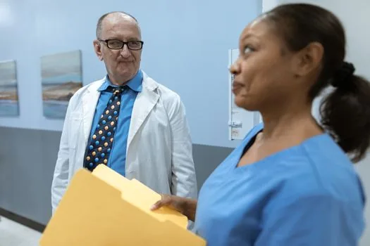 Senior patient and caregiver reviewing hospital receipt with highlighted insurance charge lines
