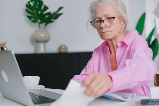 adult child checking senior parent's basic pension passbook copy and ID card on a bright kitchen table, Korean welfare document scene | 부모님 기초연금 계좌변경 전 통장사본과 신분증을 확인하는 장면