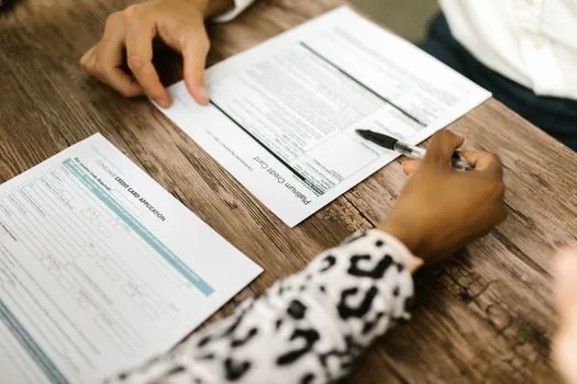adult child comparing hospital submission notice, parent medical aid certificate printout and fax number memo before sending documents, realistic Korean home photo | 병원 제출 전 서류명과 팩스번호를 대조하는 장면