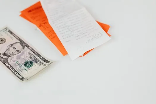 adult child filing hospital receipts, pharmacy bills and bankbook copy into labeled folders for public health center cancer expense claim, realistic photo | 진료비 영수증과 약제비 자료를 청구용으로 정리하는 장면