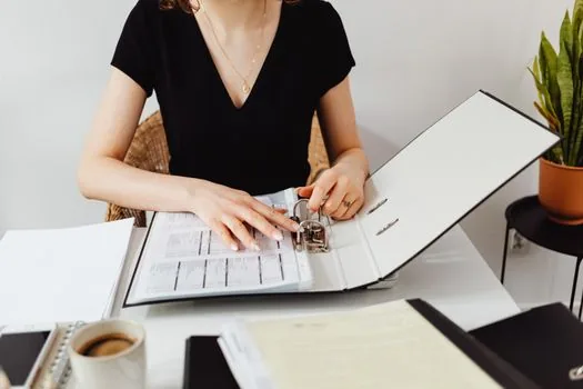 adult child organizing parent housing documents, checklist with deposit return date and local office phone number, warm home interior, realistic photo
