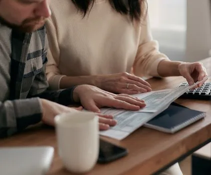 adult child organizing pension claim documents, family certificate and bankbook on a bright dining table, warm Korean home, realistic photo | 국민연금 사망일시금 청구 전 서류 정리 장면