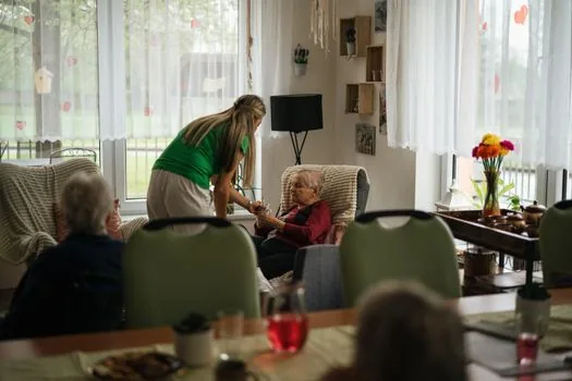 care worker helping elderly person prepare meal at home while family caregiver checks calendar, realistic Korean home care scene