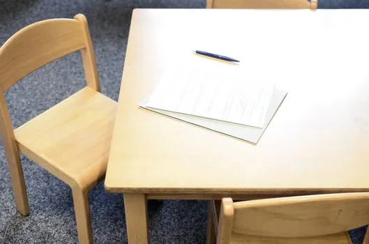 community service center consultation desk with basic pension proxy payment form, family relation certificate and pen, realistic Korean public office photo | 행정복지센터에서 기초연금 대리수령 신청서와 관계서류를 확인하는 장면
