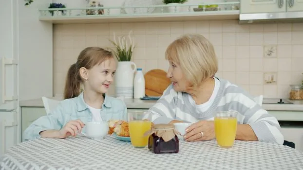 elderly parent and adult child searching forest welfare voucher available facilities on laptop with KB card and calendar, bright home table, realistic photo | 산림복지서비스이용권 사용가능 기관을 검색하는 장면