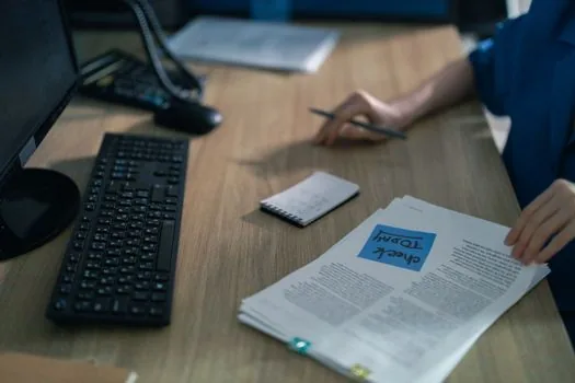 family member calling pension office with documents, bankbook copy, phone and checklist on desk, realistic Korean welfare guide photo | 국민연금공단 지사 상담 전 전화 확인 장면