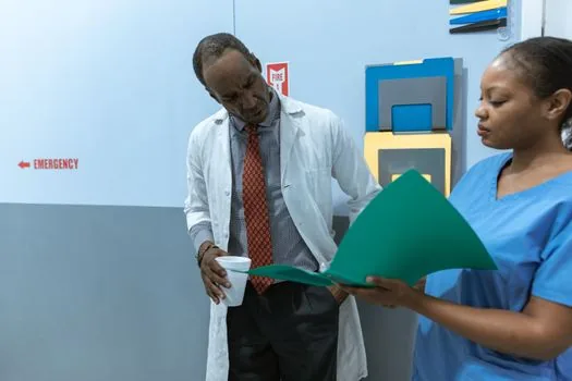 hospital social worker explaining cancer treatment bill support forms to an adult child caregiver, Korean clinic consultation desk, realistic photo | 병원 사회사업팀에서 진료비 지원 가능 항목을 상담하는 장면