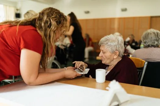 Korean community care worker helping elderly parent prepare simple meal and organize medication schedule after hospital discharge, realistic home care photo