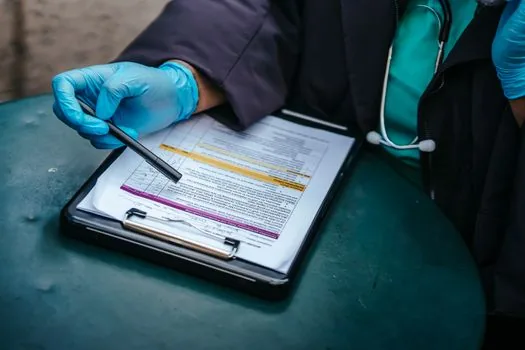 Korean daughter organizing public health center application form diagnosis paper and welfare certificate for elderly parent's knee surgery | 부모님 무릎 수술비 지원 신청서와 자격서류를 정리하는 장면