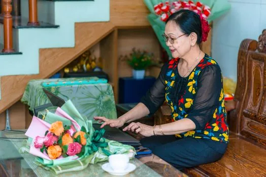 Korean family caregiver searching official health portal on laptop with elderly parent, notebook checklist, realistic warm home table photo | 국가건강정보포털에서 부모님 증상 정보를 검색하는 장면