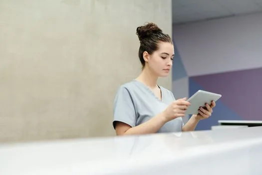 Korean senior parent and adult child checking clinic receipt and health insurance copay memo at reception desk, realistic bright medical office photo | 의원 진료비 영수증을 확인하는 장면