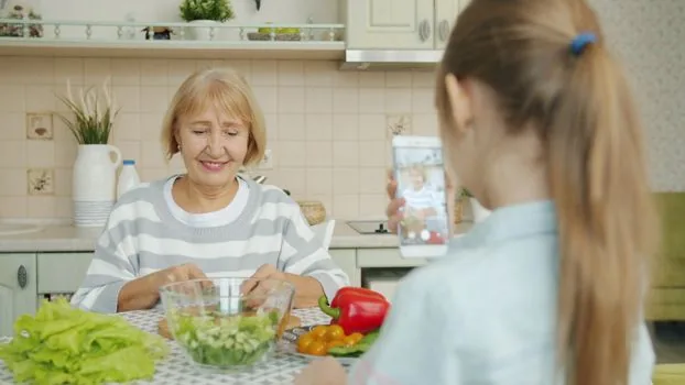 Korean senior parent checking smartphone bill with adult child and pension notice at home table