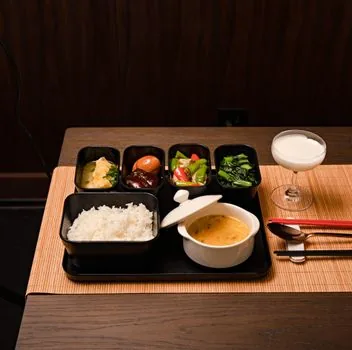 Senior meal delivery lunch box and side dish containers with family emergency contact note on refrigerator | 도시락 배달과 비상연락처를 함께 확인하는 장면