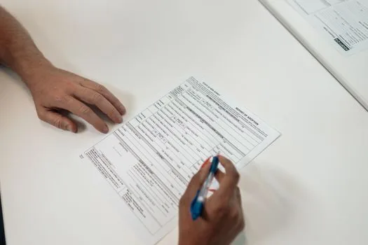 welfare appeal form with highlighted reason section, bank statement, family relation certificate and pension notice arranged on desk, realistic document preparation photo | 이의신청서 사유와 증빙자료를 맞춰 정리하는 장면