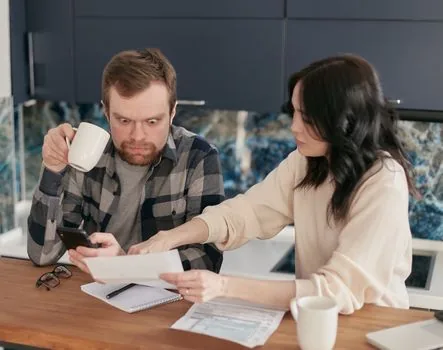 family reviewing HIRA result notice and bank account memo after medical bill review request, realistic desk photo | 진료비 확인 결과 통보문과 계좌 확인 메모를 살펴보는 장면