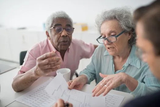 hearing aid specialist explaining registered product paperwork and barcode photo to senior family | 공단 등록 보청기 제품과 바코드 사진, 표준계약서를 확인하는 장면